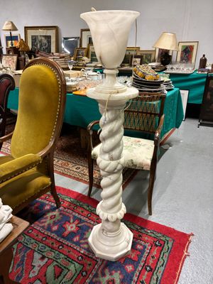 une table sur laquelle est posé un vase, dans une pièce remplie de meubles