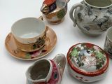many different types of tea cups and saucers on the table