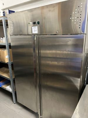 a stainless steel refrigerator in the middle of a kitchen