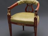 une chaise avec une assise rembourrée verte et un cadre en bois
