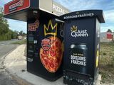 a pizza box that is sitting on the side of the road