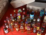 many bottles of alcohol on a table with a red cloth