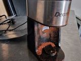 a coffee grinder sitting on a counter next to a stove