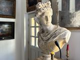 a bust of a man sitting on a pedestal in a room