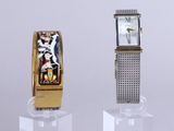 two watches sitting on display on a clear stand