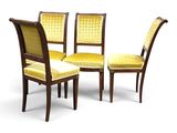 four chairs with yellow upholstered cushions and a wooden frame