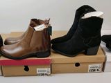 Quatre paires de bottines pour femmes se trouvent dans une boîte en carton
