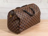 brown and black checkered duffle bag sitting on a wooden table