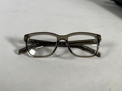 une paire de lunettes posée sur une table à côté d'une paire de ciseaux