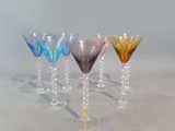 quatre verres à vin de couleurs différentes alignés en rang sur une table