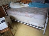 un lit sur lequel se trouvent un matelas et une imprimante