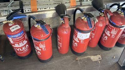 several fire extinguisors lined up in a row on a table