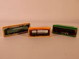 trois trains miniatures posés dans une boîte sur une table