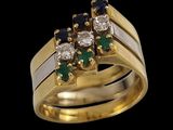 an image of a gold ring with three diamonds and emeralds