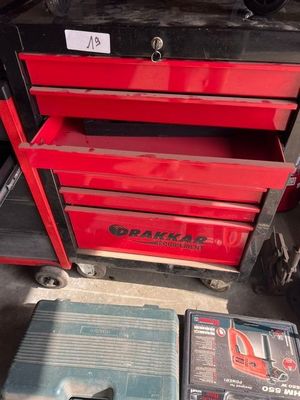 Deux caisses à outils rouges sont posées l'une à côté de l'autre dans un garage