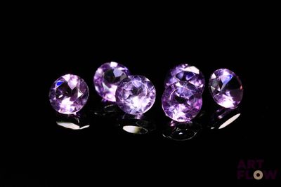 a group of purple gems sitting on top of a black surface