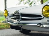 a white alfa car parked on the side of the road