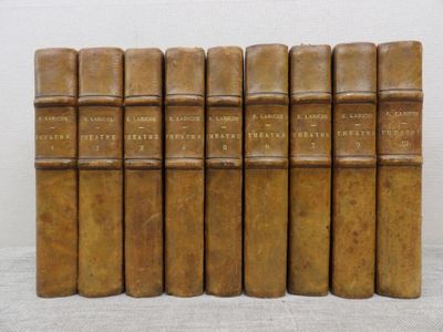 six old books are lined up on a white surface