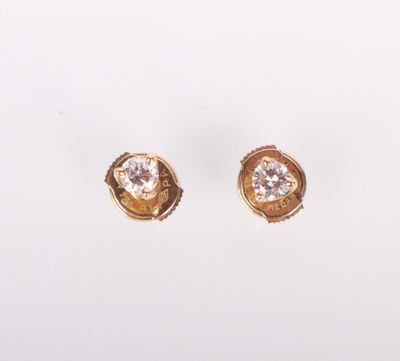 une paire de boucles d'oreilles en or et diamants sur fond blanc