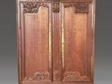 une armoire ancienne en bois ornée d'un motif sculpté sur le dessus
