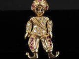 une figurine plaquée or représentant un homme coiffé d'un chapeau rouge et blanc