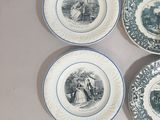 four plates with blue and white designs on them on a table