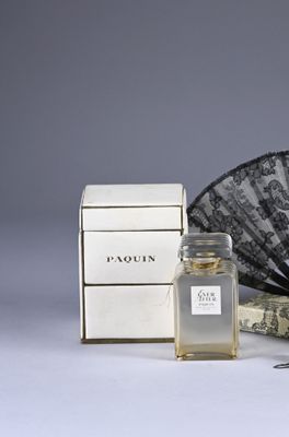 a bottle of perfume next to a fan and a box