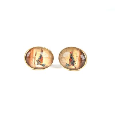 deux paires de boucles d'oreilles ornées d'une peinture, posées sur une surface blanche
