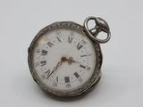 a silver pocket watch with roman numerals on it