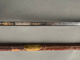 pair of old swords on a white cloth with a wooden handle