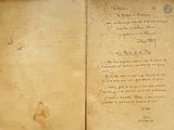 an old book with writing on it sitting on a table