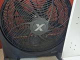 a fan that is sitting on the floor in front of a red wall