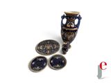 a picture of a blue vase and a plate on a white surface