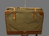 an image of a brown and tan suitcase sitting on top of a wooden stand