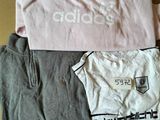 three t - shirts sitting on top of a cardboard box