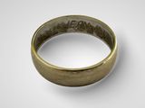 a close up of a gold ring on a white surface