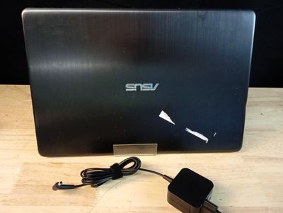 un ordinateur portable posé sur une table avec un chargeur