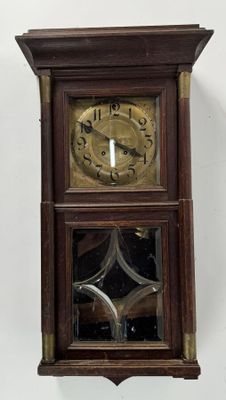 a wooden clock hanging on the wall in the room