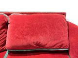 a red couch with two red pillows on top of it