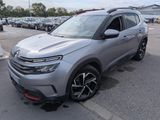 un SUV argenté garé sur un parking, avec d'autres voitures en arrière-plan