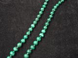 un collier de perles vertes sur fond noir