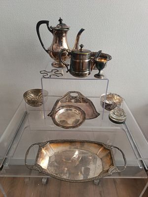 une table en verre sur laquelle sont posés des objets en argent