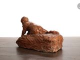 a statue of a man laying on a rock