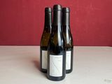 deux bouteilles de vin posées sur une table, avec un mur rouge en arrière-plan