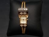 une montre en or posée sur un coussin noir, sur une surface noire