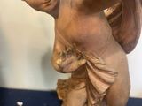 statue of a woman holding a bird on a blue surface