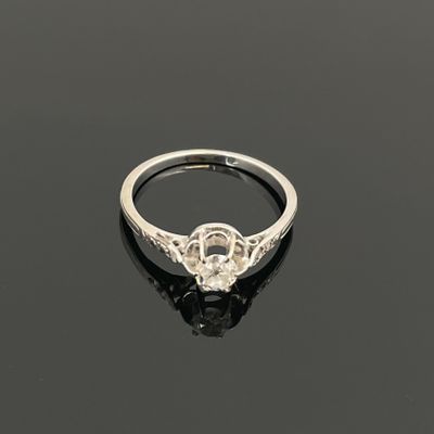 une bague en diamant et en or blanc sur un fond noir