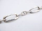 a close up of a silver chain on a white surface