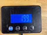 a digital clock that is on a table next to a remote control