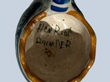 a small ceramic vase with a bird on top of it
